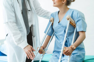 Injured woman on crutches talking to her doctor.