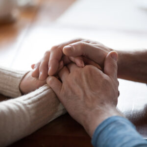 two people holding hands after a loved one has died