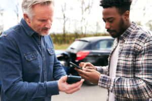 Drivers involved in car accident exchanging numbers for details.