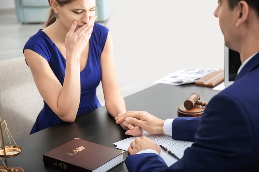 Crying spouse consulting wrongful death attorney for possible claims.