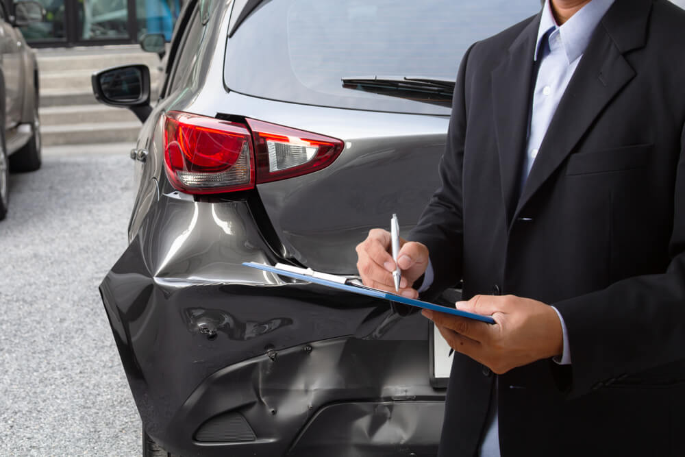 Insurance agent checking car damages from car accident.