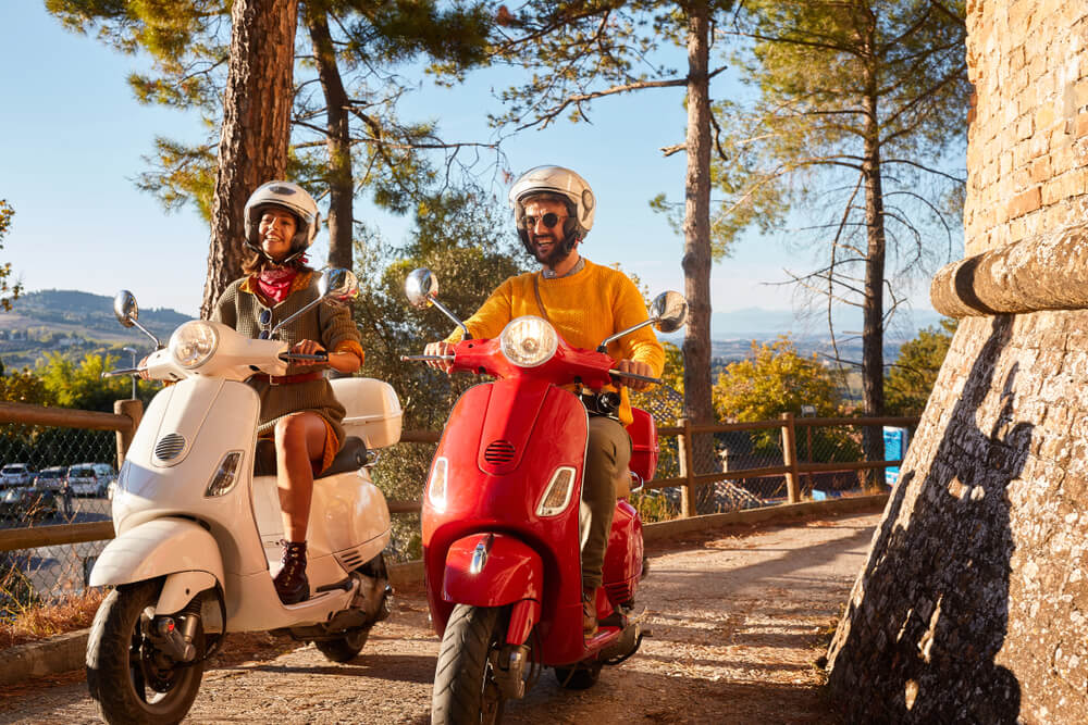 Couple riding mopeds touring the city.