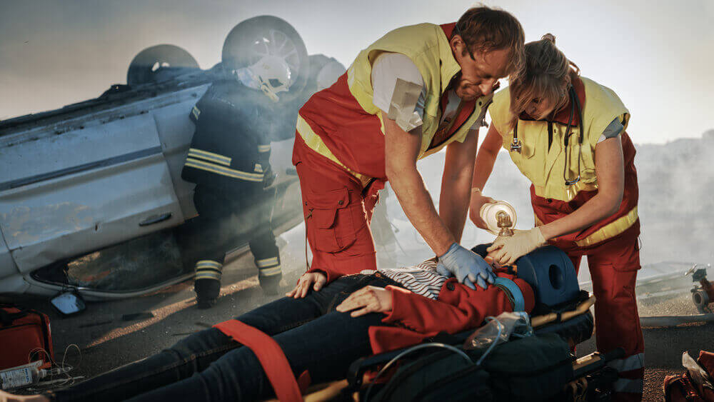 Paramedics rescuing victims from catastrophic car accident.